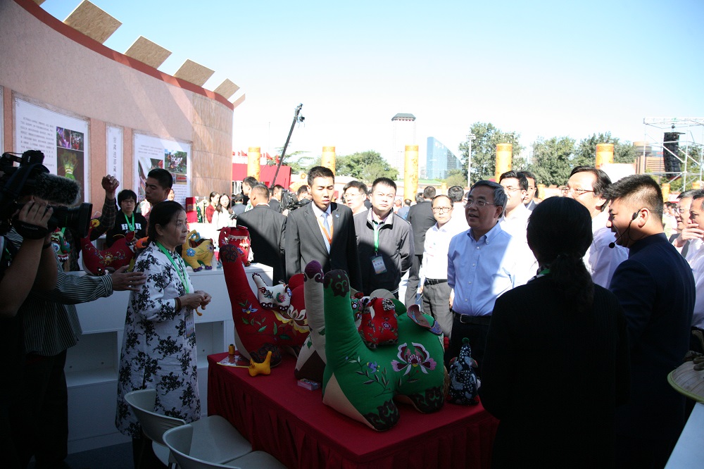 10、2018年在首届中国农民丰收节上向领导介绍北马布老虎制作技艺。摄影：马林.jpg